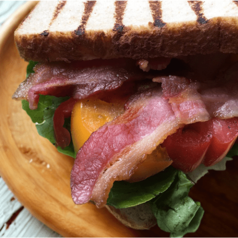 Close-up of a healthy BLT sandwich on sourdough bread with crispy bacon, heirloom tomato slices, and fresh Bibb lettuce – high-protein and Weight Watchers friendly.